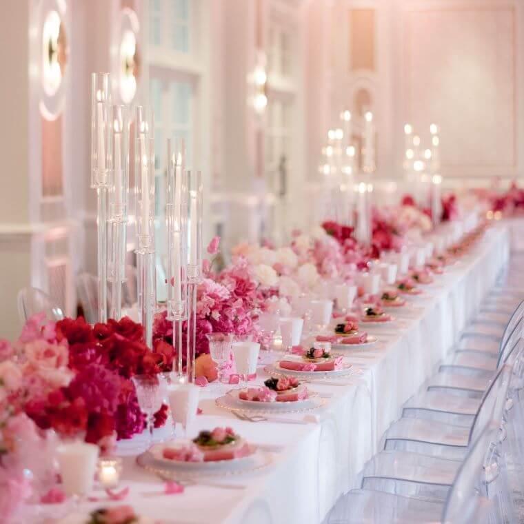 A table set with red and pink flowers by blooming haus
